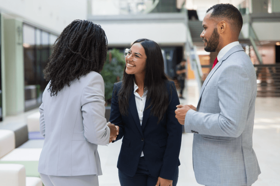 Smiling professional in a white shirt and red tie at a meeting